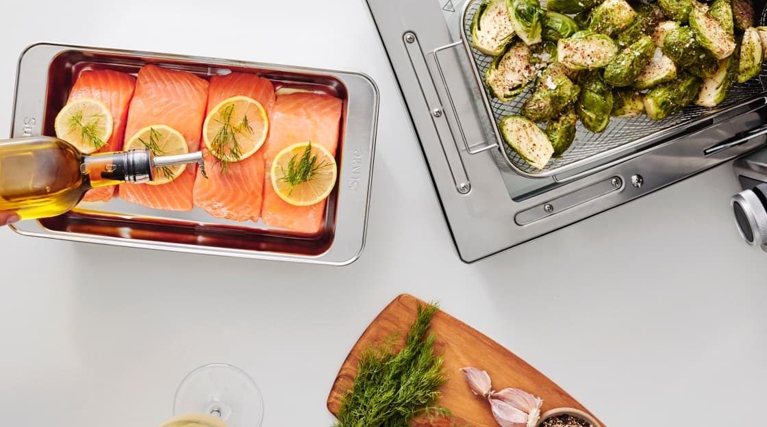 Salmon fillets, roasted vegetables, and herbs prepared with Suvie